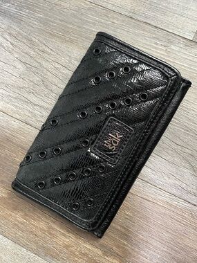The Sak Black Quilted Eyelet Trifold Leather Wallet with Logo Plaque